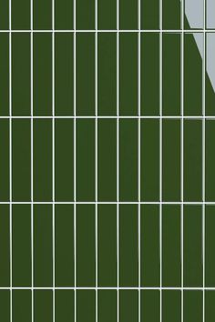 a green tiled wall with white lines on it