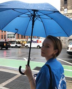 a woman holding an umbrella in the rain