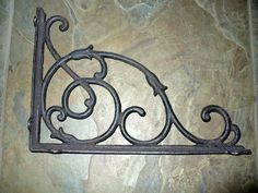 an old iron shelf bracket on a stone wall in a room with marble flooring