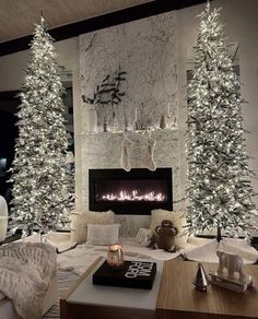 the living room is decorated with white christmas trees and stockings on the fireplace mantel