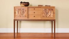 a wooden cabinet with two drawers and a bowl sitting on it's sideboard