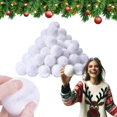 a woman is holding cotton balls in front of her face and christmas decorations behind her