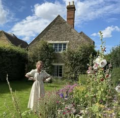 a woman standing in the middle of a garden