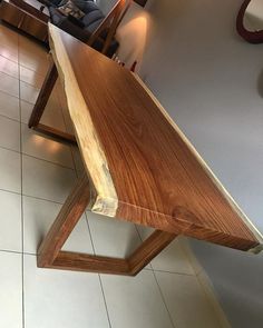 a wooden table sitting on top of a tiled floor