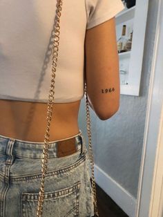 the back of a woman's waist with a small tattoo on her left arm