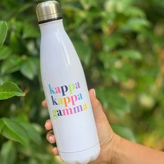 a person holding a water bottle with the words kappa kappa gamma on it