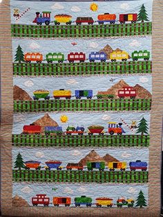 a quilted wall hanging with trains on it