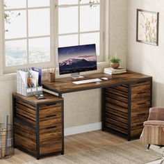 a desk with a computer on it in front of a window