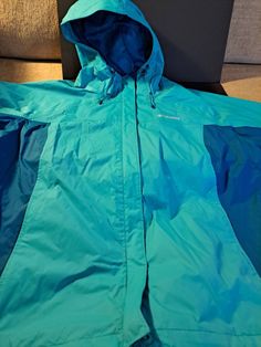 To tone teal, 2x, Columbia windbreaker/rain jacket. Great condition.  Zips and velcro close. Wrist velcro to keep out wind. Blue Windproof Windbreaker For Rainy Weather, Green Nylon Windbreaker For Cold Weather, Green Weatherproof Windbreaker For Rainy Weather, Green Sporty Outerwear For Rainy Weather, Sporty Green Outerwear For Rainy Weather, Green Waterproof Windbreaker For Cold Weather, Sporty Green Windbreaker For Rainy Weather, Green Raincoat With Pockets For Hiking, Green Nylon Windbreaker For Rainy Weather