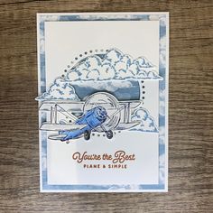 a blue and white card with an airplane in the sky on it's side