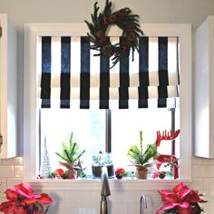 a kitchen window decorated for christmas with poinsettis