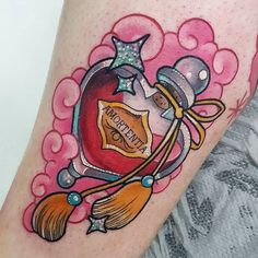 a woman's leg with a tattoo on it that has a heart and broom