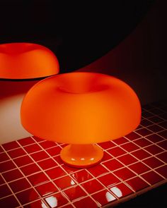 an orange table lamp sitting on top of a red tiled counter