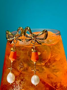 Sip the day away in the Aperol Spritz earrings. The spring ring attachment allows the Aperol Spritz charm to be clipped onto most Bunx necklaces, bracelets, or earrings. 🍹 Details 🍹 ✱ 18k gold coated brass ✱ Enamel coating ✱ Baroque pearl Plated Drop Clip-on Earrings As Gift, Metal Clip-on Earrings With Plating For Gift, Metal Clip-on Earrings With Plating As Gift, Metal Plated Clip-on Earrings For Gifts, Metal Plated Clip-on Earrings As Gift, Chic Gold-tone Clip-on Earrings For Gift, Gold-tone Clip-on Earrings, Gift Gold-tone Clip-on Earrings, Elegant Orange Gold-plated Jewelry