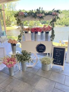 an outdoor stand with flowers and signs on it