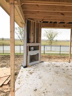 an unfinished room with a fireplace in the middle and wood framing on the outside wall