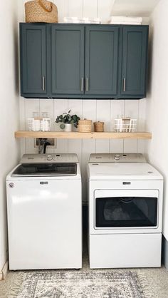 a washer and dryer sitting next to each other in a room with blue cabinets