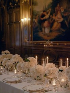 the table is set with white flowers and candles