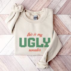 this is my ugly sweater on a wooden floor with the words ugly written in red and green