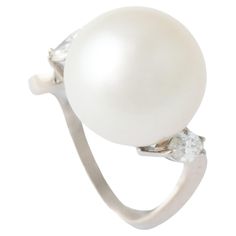 Elevate your elegance with our Cultured Pearl Diamond White Gold Ring—a true embodiment of sophistication and grace. At its heart lies a magnificent cultured pearl, boasting dimensions of 13.7 mm and a weight of 13.97 carats. The pearl’s enchanting blend of white, cream, and pink hues adds a touch of timeless beauty to the ring. Flanking the pearl are two marquise-cut diamonds, totaling approximately 0.53 carats. With an estimated E color and remarkable clarity, these diamonds bring a dazzling brilliance to the piece. Set in lustrous white gold, the ring is a harmonious fusion of classic charm and modern refinement. Adorn yourself with this radiant masterpiece, where the allure of cultured pearls meets the brilliance of diamonds, creating a statement ring that captures the essence of endur Diamond And Pearl Engagement Ring Zales, Luxury White Pearl Ring With Single Cut Diamonds, Marquise Cut Diamond, Pearl Diamond, White Gold Ring, Marquise Cut, Cultured Pearls, White Cream, White Gold Rings