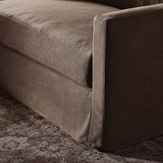 a brown couch sitting on top of a carpet covered floor