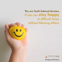 a hand holding a smiley face ball with the words you are god's beloved devotee, if you can stay happy in difficult times, without claiming others