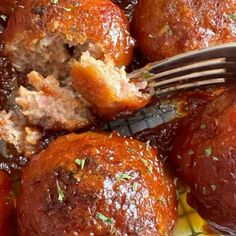 a fork digging into some meatballs on a plate