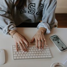 a woman is typing on her computer keyboard