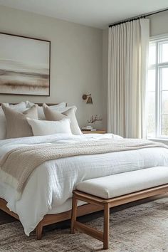 a bed with white linens and pillows in a bedroom next to a large window