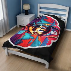 a bed covered in a black and red comforter with an image of a bear on it