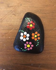 a painted rock sitting on top of a wooden table