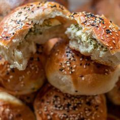 several bagels with sesame seeds and cheese are piled up on top of each other