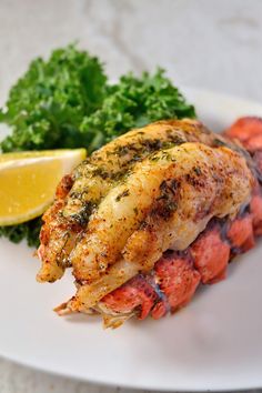 a plate with lobster, lemon and parsley on it