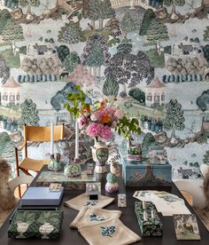 a dining room table with flowers in vases on it and wall paper behind the table