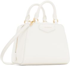 Structured and tumbled buffalo leather top handle bag in white. · Twin rolled carry handles · Adjustable and detachable crossbody strap · Logo stamp at face and back face · Two-way zip closure · Card slot at interior · Canvas lining · Logo-engraved gold-tone hardware · H5.5 x W6.5 x D3.5 Supplier color: Ivory White Bag With Gold-tone Hardware And Round Handle, White Bags With Gold-tone Hardware And Round Handle, Designer White Bag With Round Handle, White Satchel With Double Handle And Handle Drop, Everyday White Satchel With Round Handle, White Double Handle Satchel With Handle Drop, White Satchel With Detachable Strap And Round Handle, White Travel Bag With Round Handle, White Shoulder Bag With Round Handle For Travel