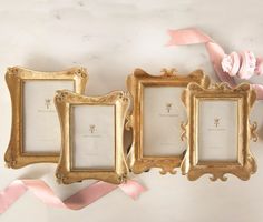 three gold frames with pink ribbons and flowers