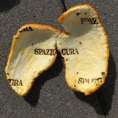 two pieces of bread sitting on top of a cement ground with words written in them