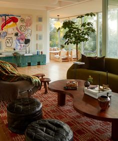 a living room filled with lots of furniture and large windows overlooking the trees in the distance