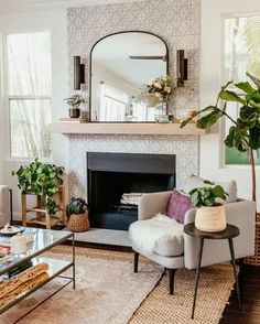 a living room filled with furniture and a fire place in front of a mirror on the wall