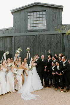 a large group of people standing next to each other in front of a wooden building