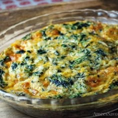 a casserole dish with spinach and cheese in it on a wooden table