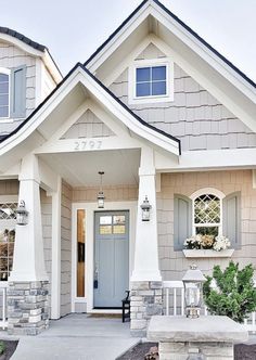 the front entrance of a house with blue doors and windows