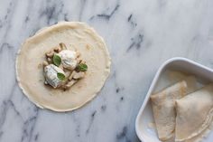 a white plate topped with food next to a bowl filled with ice cream and tortilla shells