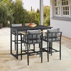 an outdoor dining table with chairs and a bowl of fruit on the outside patio area