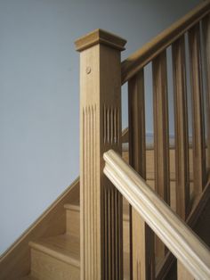 a wooden stair case next to a hand rail