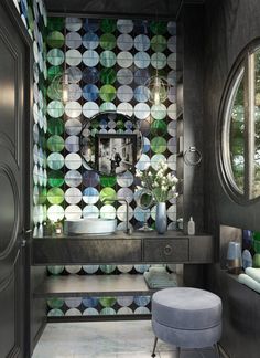 a modern bathroom with circular mirrors and patterned wallpaper on the walls, along with a stool