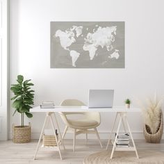 a white desk with a laptop on it in front of a wall mounted world map