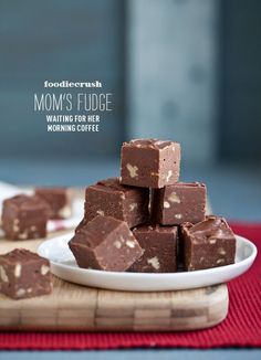 several pieces of fudge chocolate on a white plate next to a red place mat