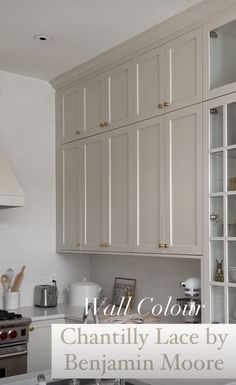 a white kitchen with lots of cabinets and counter top space in front of the stove