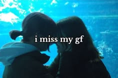 two girls looking at an aquarium with the words i miss my gf